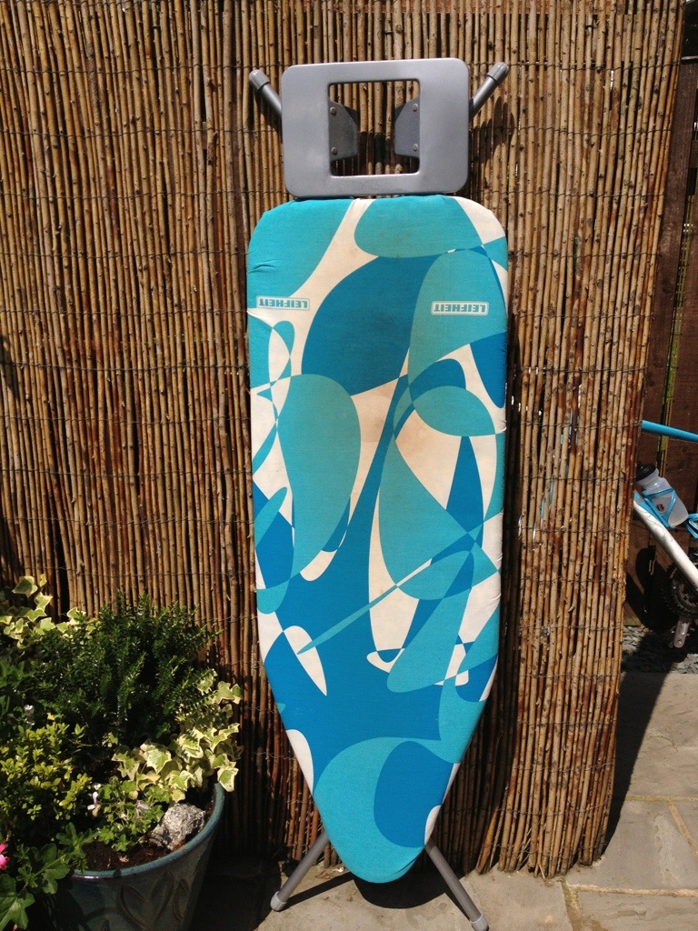 Old stained ironing board cover