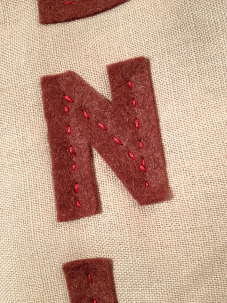 and some letters cut out of felt hand stitched with red embroidery thread.